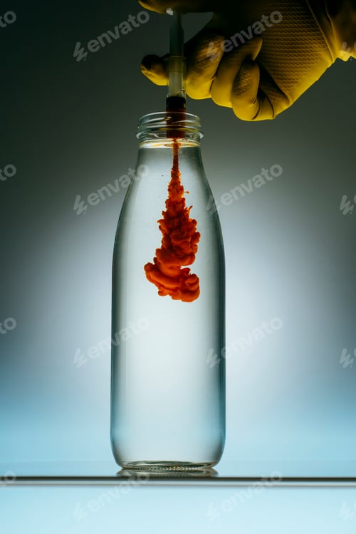 Preview: cropped view of person pouring blood from syringe into bottle with water