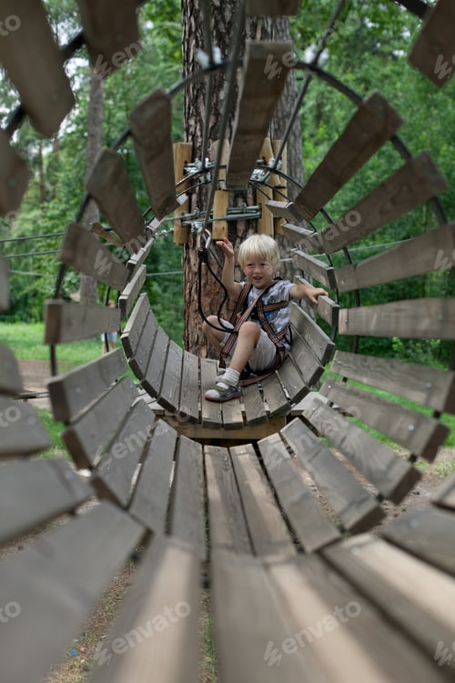 Preview: A child in a rope park climbs through the rides