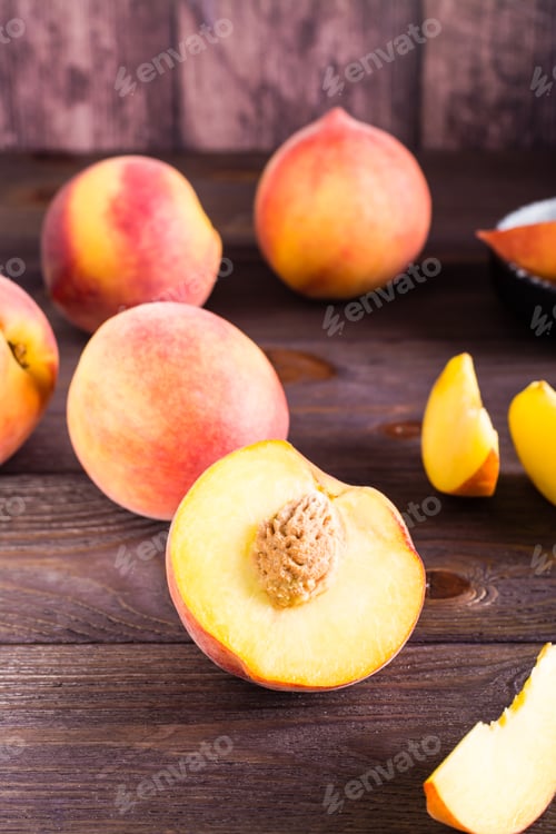 Preview: Fresh peaches sliced and whole on a wooden table. Organic vitamin food. Vertical view