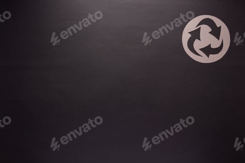 Preview: Recycle symbol on black paper as background texture. Recycling concept