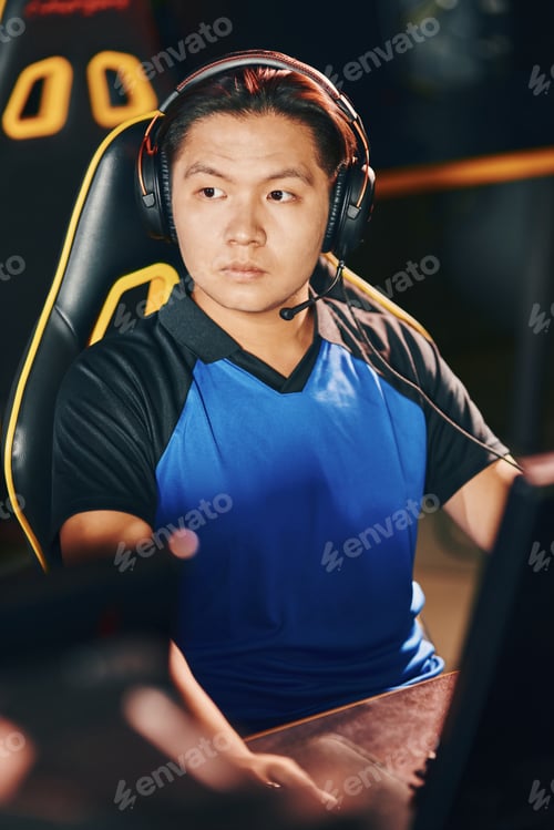 Preview: Portrait of a young asian guy wearing headphones looking aside