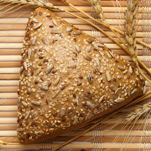 Seeded Bread Triangle with Wheat on Bamboo Mat
