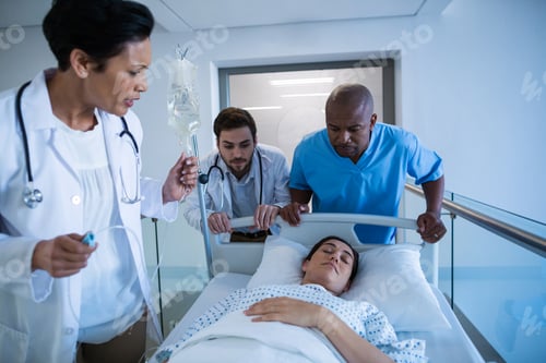Preview: Doctors adjusting iv drip while patient lying on bed