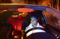 Preview: Black woman driver hold smartphone sitting on driver seat in car. Woman use gps navigation to drive