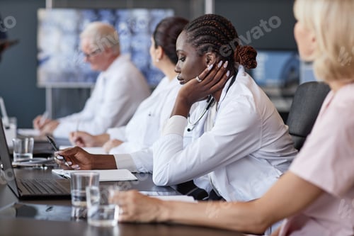 Preview: Black Woman Writing Notes during Colleagues Speech at Meeting in Radiologists Office