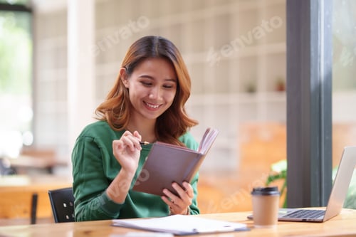 Preview: Beautiful young Asian woman student are reading book and taking notes of their studies and the detai
