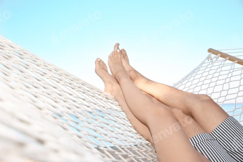 Preview: Couple Relaxing in Hammock Overlooking Blue Ocean
