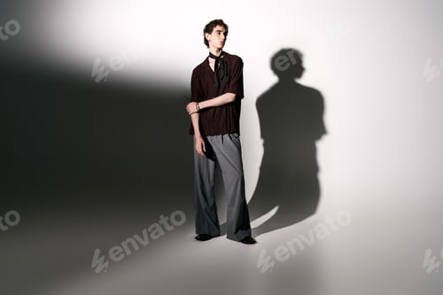Preview: Fashionable young man stands confidently in stylish attire showcasing modern elegance