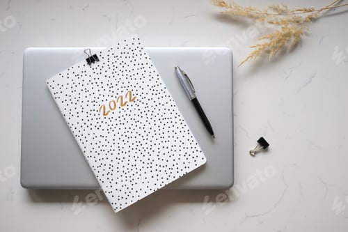 Preview: Calendar for 2022 ,planner, pen, laptop, items flat lay, minimalist.