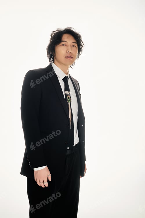Preview: Young man exudes charm and style in contemporary urban setting with striking fashion choices