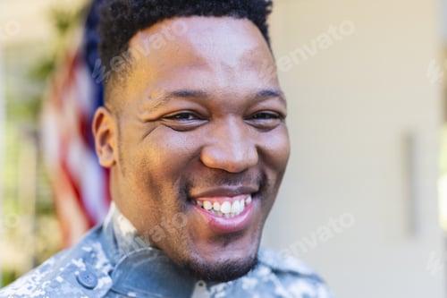 Preview: Happy african american male soldier face close up outside home with usa flag, copy space