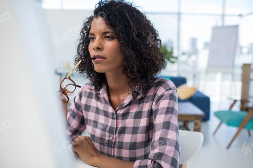 Preview: Female executive working on computer at desk