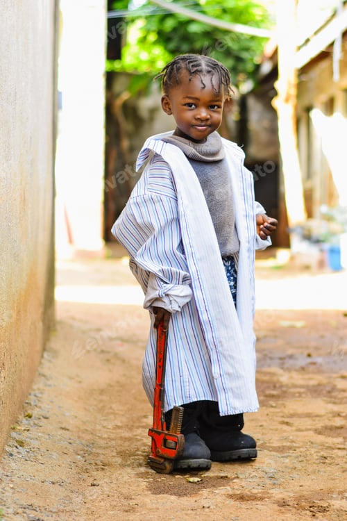 Preview: Adorable Child Dressed in Oversized Clothes with Wrench