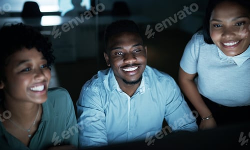 Preview: Shot of a group of young businesspeople using a computer together during a late night at work