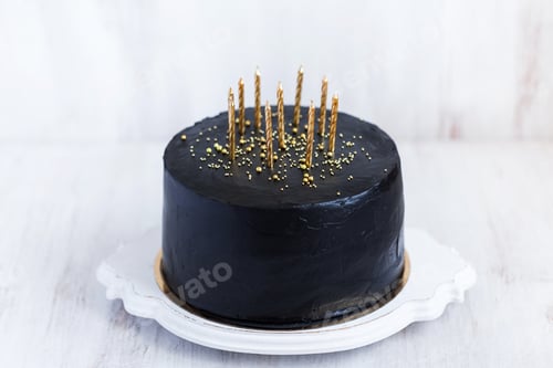 Visualização: Bolo de aniversário preto com velas douradas sobre fundo branco