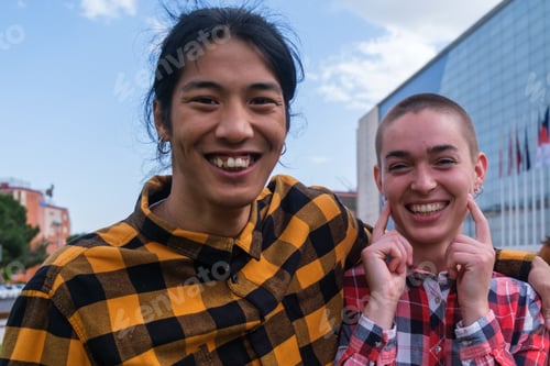 Preview: Two friends of different ethnic groups in checkered shirts outdoors