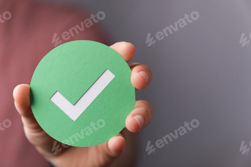 Preview: Hand holding a green paper with the checkmark sign on it