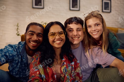 Preview: Multiracial group of happy friends gathering at home and looking at camera.