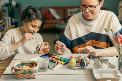 Preview: A mother and daughter painting Easter eggs, smiling