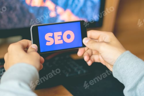 Preview: young male worker holding a smartphone with SEO text design in the office, search engine