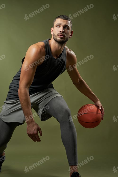 Preview: Strong basketball player with muscular body in action isolated on green background