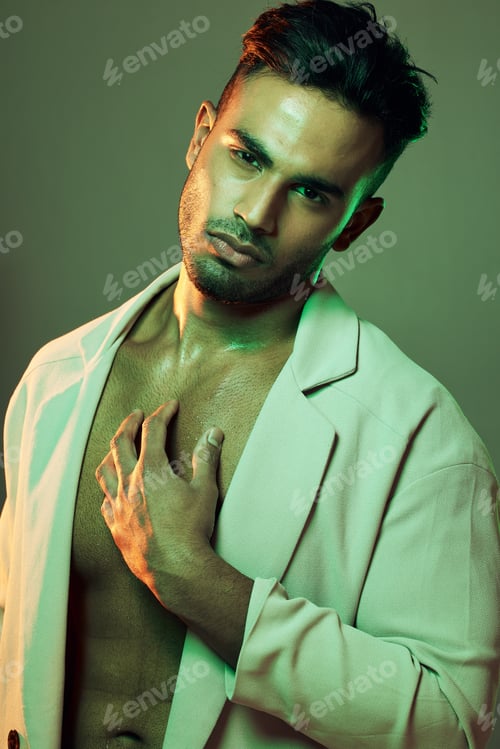 Preview: Beauty, green lights and portrait of sexy man from India touching bare chest in creative studio sho