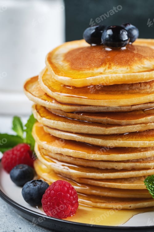 Preview: Delicious pancakes, with fresh blueberries, raspberry and maple syrup or honey on a dark background