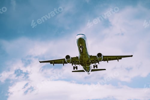 Preview: Closeup shot of a white airplane flying in the sky on a cloudy day