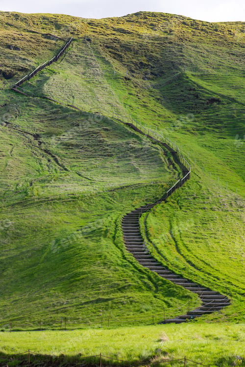 Preview: Small path leading up a green hill near Skogafoss waterfall, Iceland