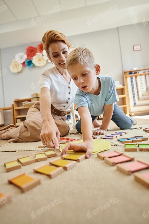 Preview: montessori school, blonde boy playing educational game near female teacher, motion, color matching