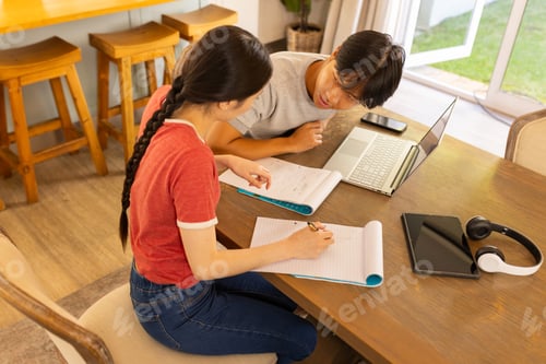 Preview: Studying together, two students using laptop and notebooks table