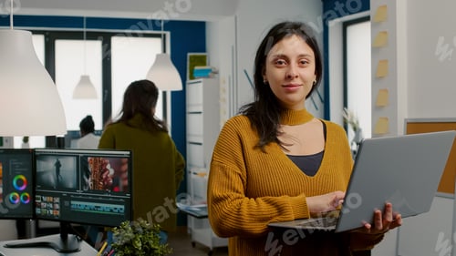 Preview: Woman retoucher looking at camera smiling working in creative media agency