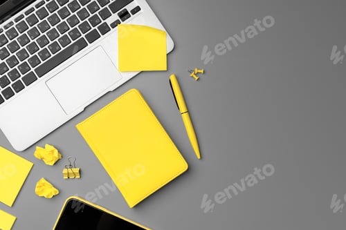 Preview: Yellow notepad with smartphone and pen on gray background