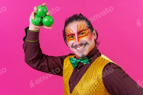 Preview: Cheerful circus performer skillfully juggling a number of clubs isolated on pink background