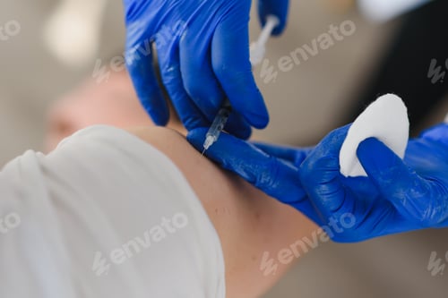 Preview: Close up of a Doctor making a vaccination in the shoulder of patient,