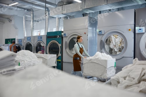 Preview: A woman worker is pushing a cart filled with clothes in a laundromat