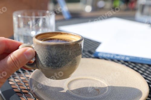 Preview: Human hand holding a cup of espresso