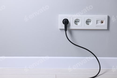 Preview: Power sockets and electric plug on grey wall, space for text