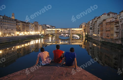 Preview: Horizontal shot of three friends enjoying the beautiful view of buildings with lights and the water