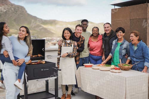 Preview: Multiracial friends with different ages having fun together during house rooftop barbecue party
