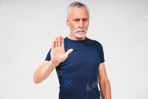 Preview: Portrait of mature grey-haired man showing stop sign over white background isolated