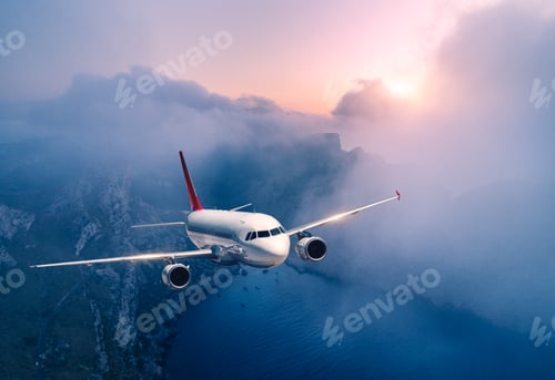 Preview: Passenger airplane is flying over clouds at sunset