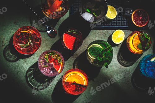 Preview: Alcoholic cocktails and bar tools on green background, top view