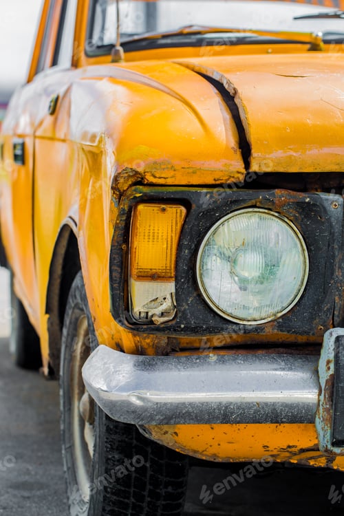 Preview: Vintage car yellow. Closeup. Broken.