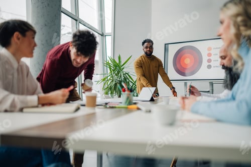 Preview: Marketing team analyzing global market data during office presentation