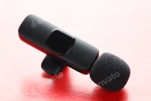 Preview: Lavalier microphone on color background, closeup. Audio equipment