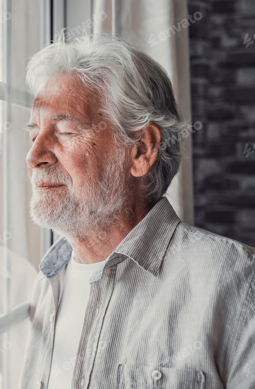 Preview: Happy thoughtful older 70s man looking out of window away with hope
