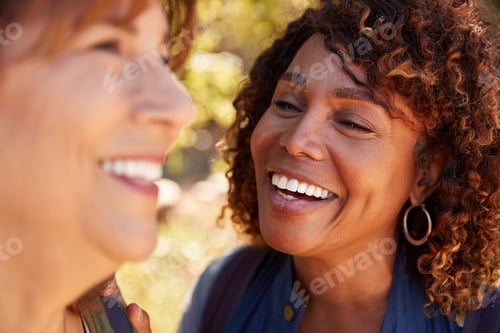 Preview: Two Senior Female Friends Hiking Along Trail In Countryside Together