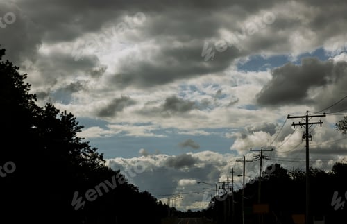 Preview: Majestic thunderstorm clouds above a trees with road in dramatic stormy clouds