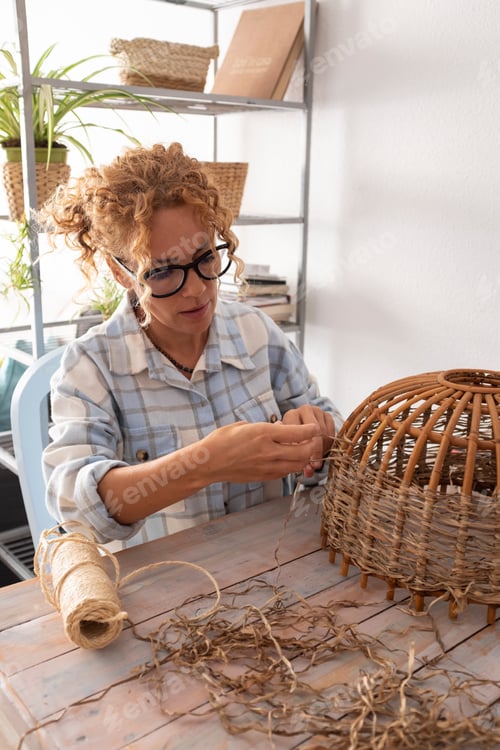 Preview: Woman at home in indoor leisure hobby activity do a wicker lamp with handcraft creative homework